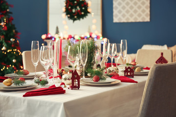 Stylish table setting with burning candles and Christmas decorations