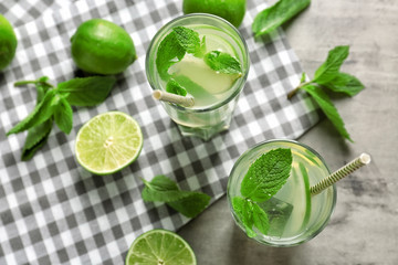 Glasses of fresh mojito on light table