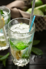 Glass of fresh mojito on wooden table