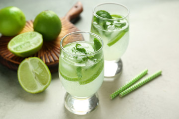 Glasses of fresh mojito on light table