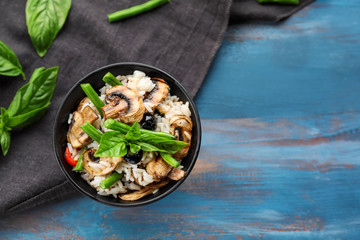 Bowl with tasty boiled rice and vegetables on wooden table