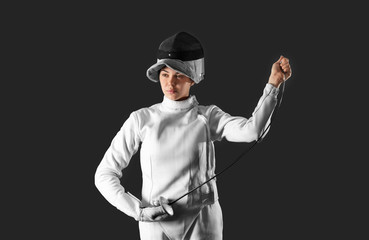 Young female fencer on dark background
