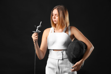 Young female fencer on dark background