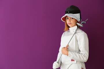 Young female fencer on color background