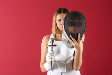 Young female fencer on color background