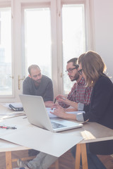 Group of young architects in the sunny office.