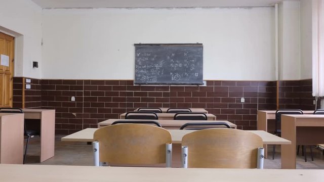 Auditorium slider of empty rows of wooden desks with chairs