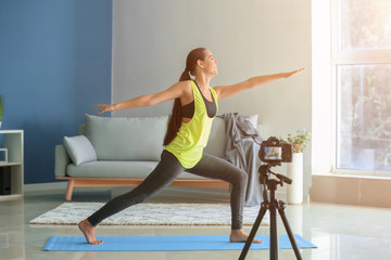 Young female blogger recording sports video at home