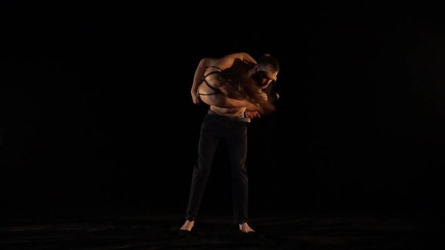 A woman jumps a man in his arms and he spins it, a pair of acrobats. Bit slow motion