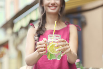 Young woman with mason jar of fresh lemonade outdoors