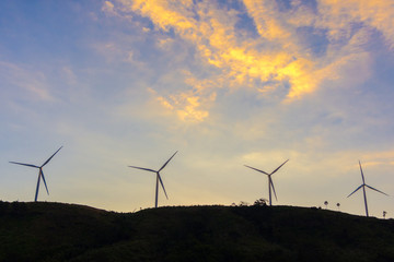 Fototapeta na wymiar Wind turbine on the hill with cloud sky background.