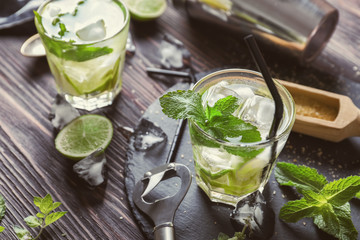 Glasses of fresh mojito on wooden table