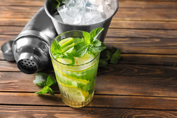 Glass of fresh mojito on wooden table