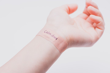 Suicide prevention concept: A band aid on wrist with hand writing "Calm down".