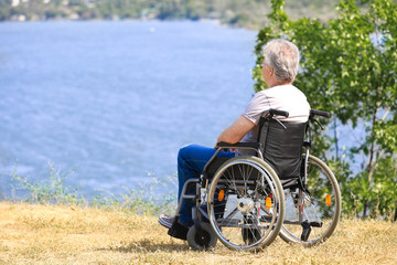 Senior man in wheelchair near river