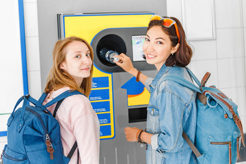 Woman friends together at the reverse vending machine recycle plastic bottles, ecology concept