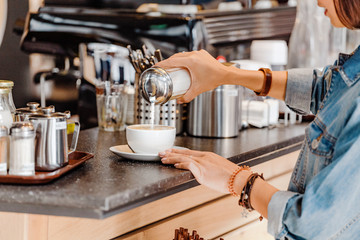 Closeup woman pouring sugar into tea or coffee cup