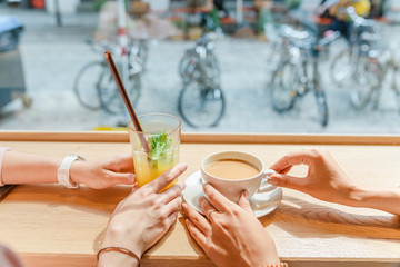 Two happy girls having lunch in a cafe, drinking coffe and talking. Friendship and lifestyle concept