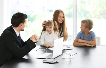 Young woman and her children meeting with headmaster at school