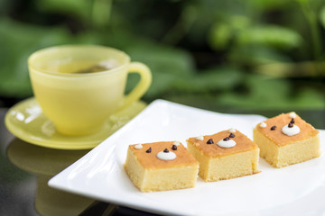 Tree cute bear face butter cakes on wooden chopping board with tea cup on the table