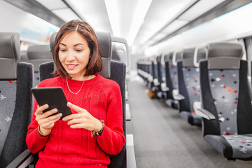 Happy Asian woman using mobile phone app in train