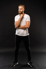 Full length portrait of a happy casual man standing isolated on a gray background.