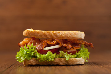 Toasted sandwich with bacon, tomato, cucumber and lettuce.