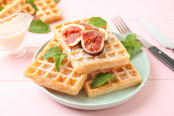 Delicious waffles with fig slices on plate