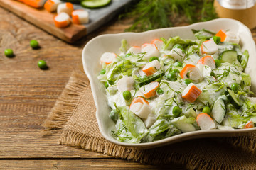 Crab sticks salad with peas, cucumber and mayonnaise.