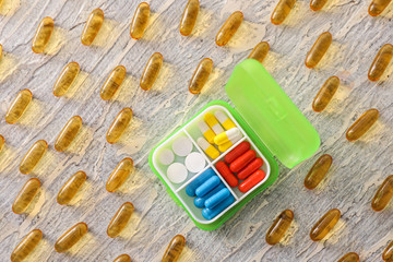 Plastic container with pills on table