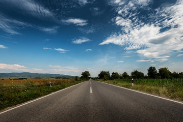 Low Angle of a straight Asphalt Road through pastoral landscape