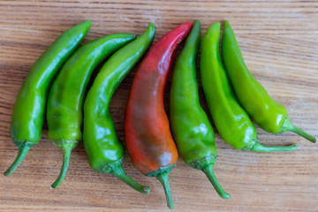 red and green spicy chili peppers on a cutting board