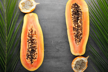 Summer composition with tropical fruits and leaves on grey background