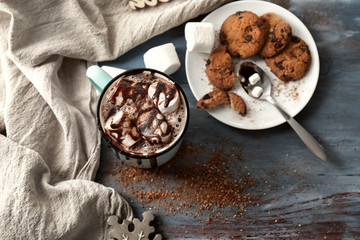 Metal cup of hot chocolate with marshmallows on table