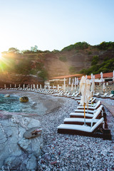 empty sun loungers on beach of adriatic sea with sunlight in Budva, Montenegro