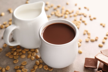 Cup of hot chocolate with milk on grey table