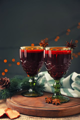 Glasses of delicious mulled wine on wooden board