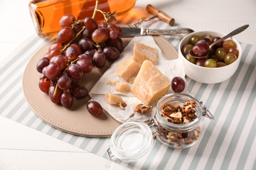 Fresh ripe juicy grapes with cheese and nuts on table