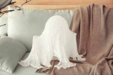 Creative ghost prepared for Halloween celebration on sofa