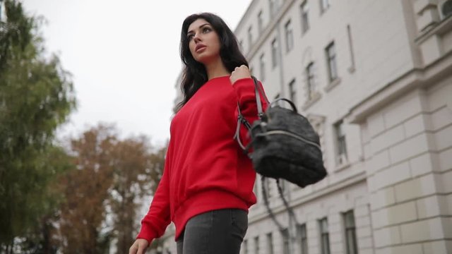 Woman wear little backpack walking in city street