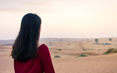 Fototapeta premium Woman walking in the desert at sunset