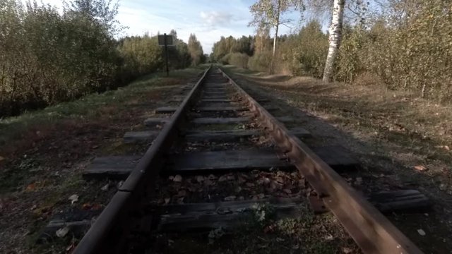 The camera is moving over the old coutryside railway tracks, wide angle perspective point of view