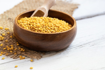 trockene gelbe linsen in einer holzschale