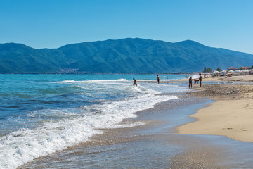 Fototapeta premium Asprovalta, Greece - August 10, 2018: Asprovalta and New Vrasna resort, Asprovalta beach. Sea view to Asprovalta at the foot of the green hills. 