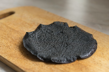 Burnt pancake on a wooden stand