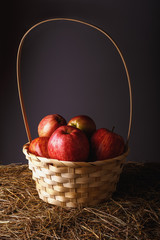 ripe red apples in a beautiful straw basket close-up