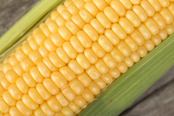Fresh corn on cobs on rustic wooden table, closeup
