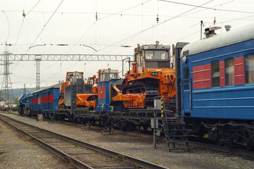 Fototapeta na wymiar train for accident recovery work with heavy bulldozers on platforms is on the siding