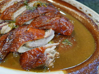 Close up of appetizing sliced roasted duck served on a plate with its sauce poured all over the meat