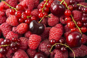 Background of raspberries, red currants and cherries. Fresh berries closeup. Top view. Background of red berries. Various fresh summer fruits. Red raspberries.